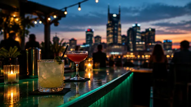 A rooftop bar at dusk with cocktails on a green-lit counter